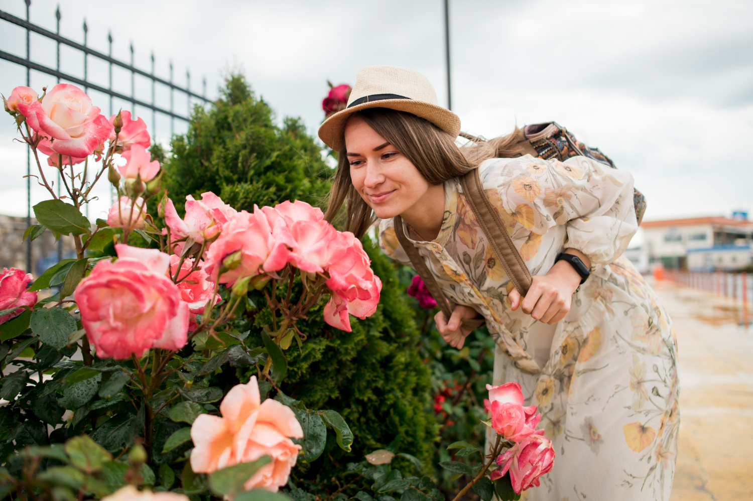 Portrait of beautiful woman with hat smelling flowers.jpg